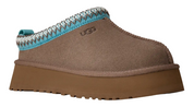 Brown UGG slipper with blue and gray trim on a white background