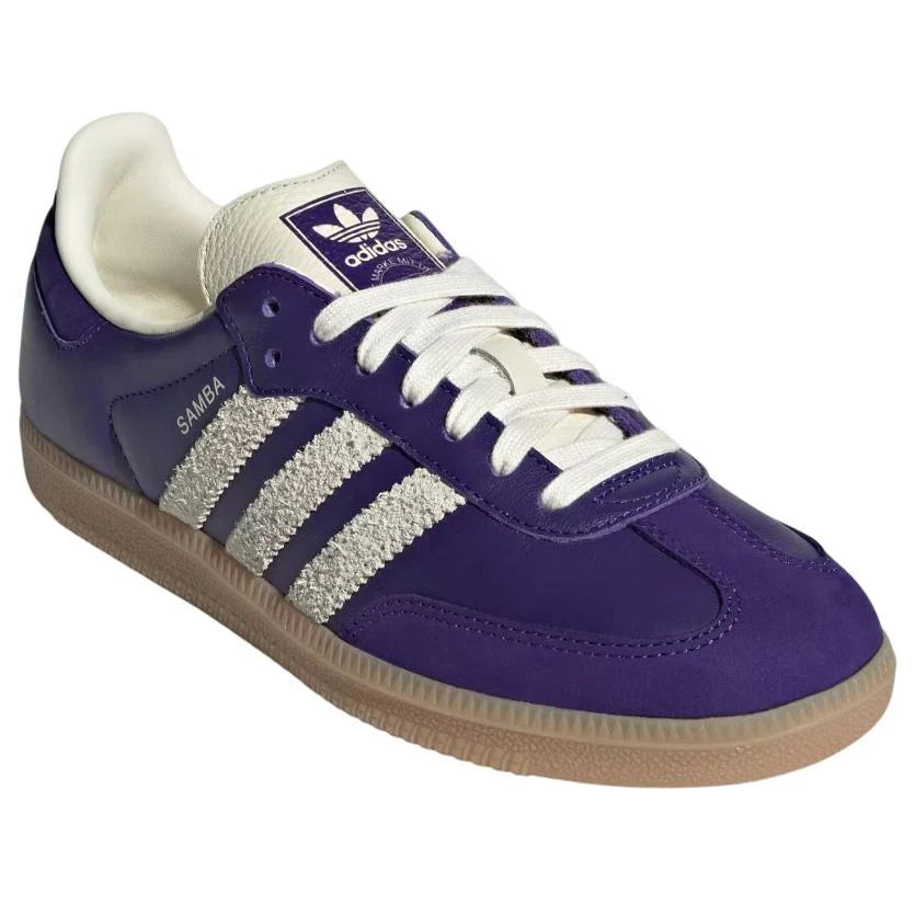 Purple Adidas sneaker with white stripes on a white background