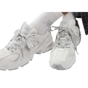 White sneakers worn with white socks on a white background