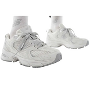 White sneakers worn with white socks on a white background